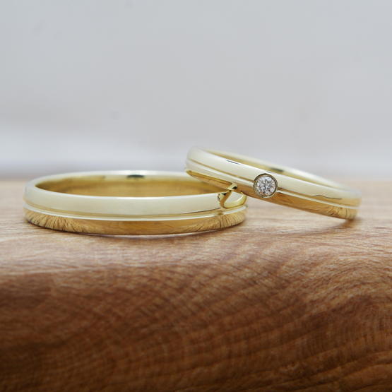 Leštěné snubáky ze žlutého zlata s drážkou na středu a přírodním 2mm diamantem